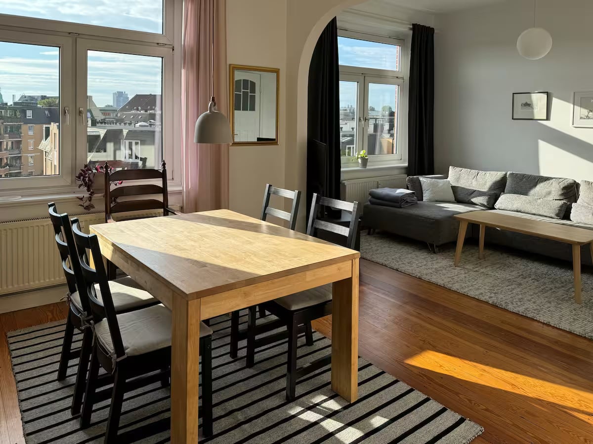 Wohnzimmer mit Esstisch und Stadtblick